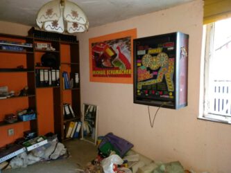 2020-10-03 Erstes Geschoss. Ein Durchgangszimmer. Man beachte das Michael-Schumacher-Plakat und den Spielautomaten.