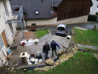 2022-02-04 Jens hilft beim Hochwuchten des Steins für die Sitzbank.